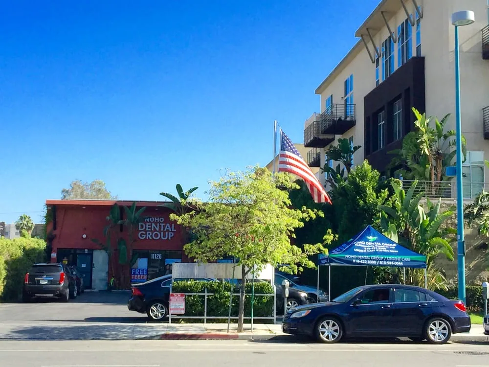 Street view of the office building with an American flag and a parked car