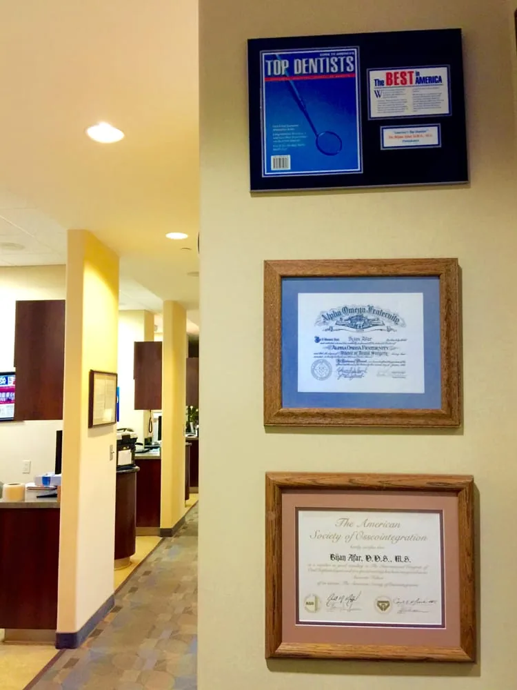 Hallway wall with a Top Dentists plaque and framed diplomas